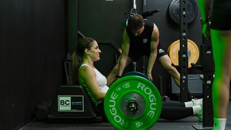 Habitat Gym member performing a barbell strength exercise with coach supervision in Prestons facility.