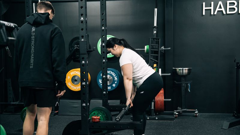 Busy professional working out with a personal trainer at Habitat Gym after work.
