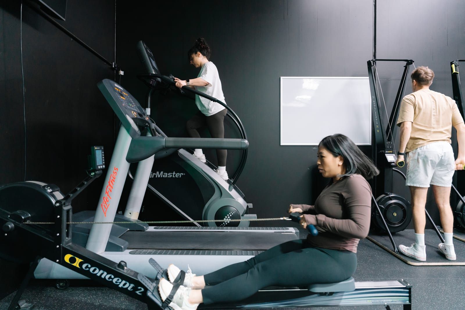 Members training on the stair climber and Concept2 rower in Habitat Gym’s cardio zone