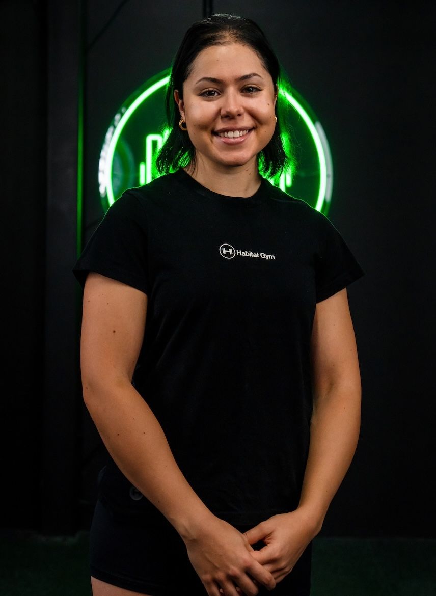 Isabelle, coach and Performance Nutrition and Pre/Post Natal Coach at Habitat Gym, smiling inside Western Sydney gym