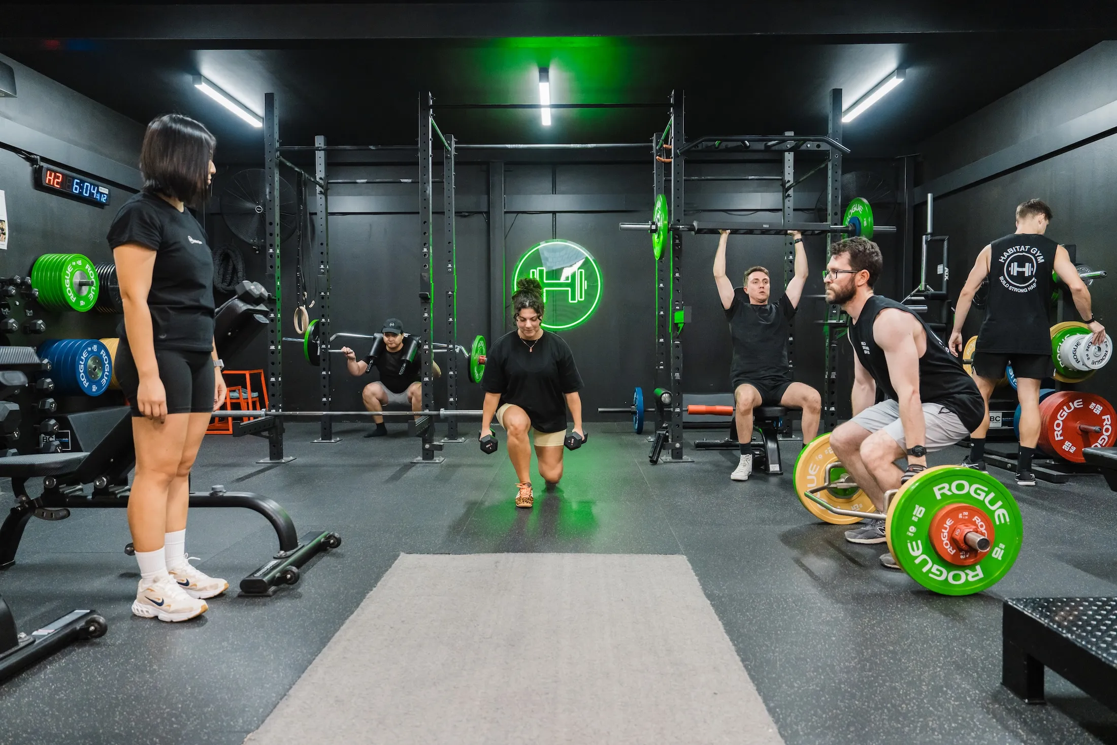 Clients performing lunges and deadlifts while coaches supervise during a group session at Habitat Gym in Prestons