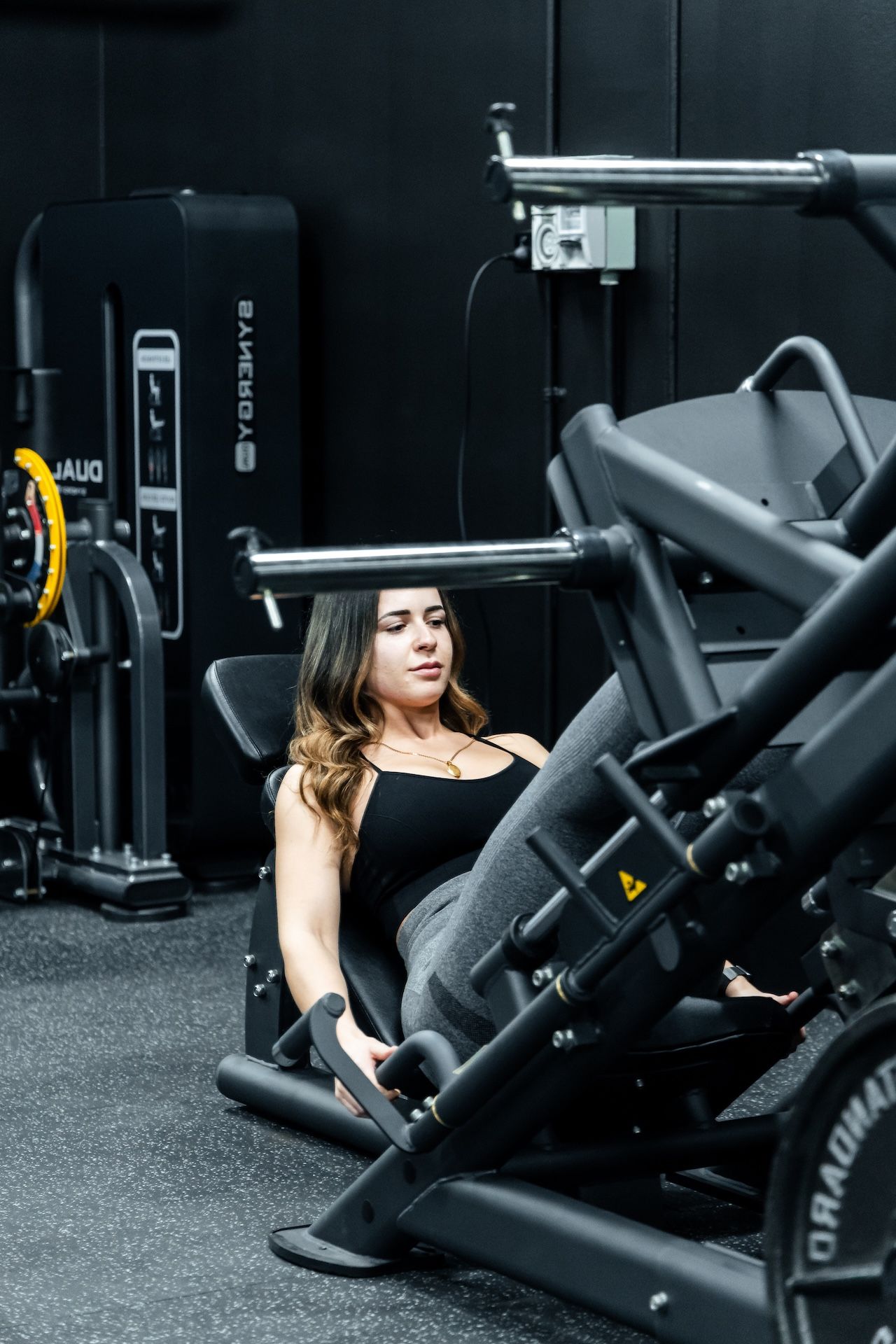 Female gym member training on leg press machine in Habitat Gym’s machine area