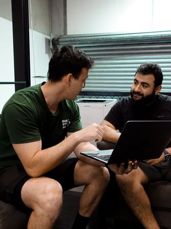 Trainer and member reviewing progress on a laptop during a one-on-one nutrition check-in