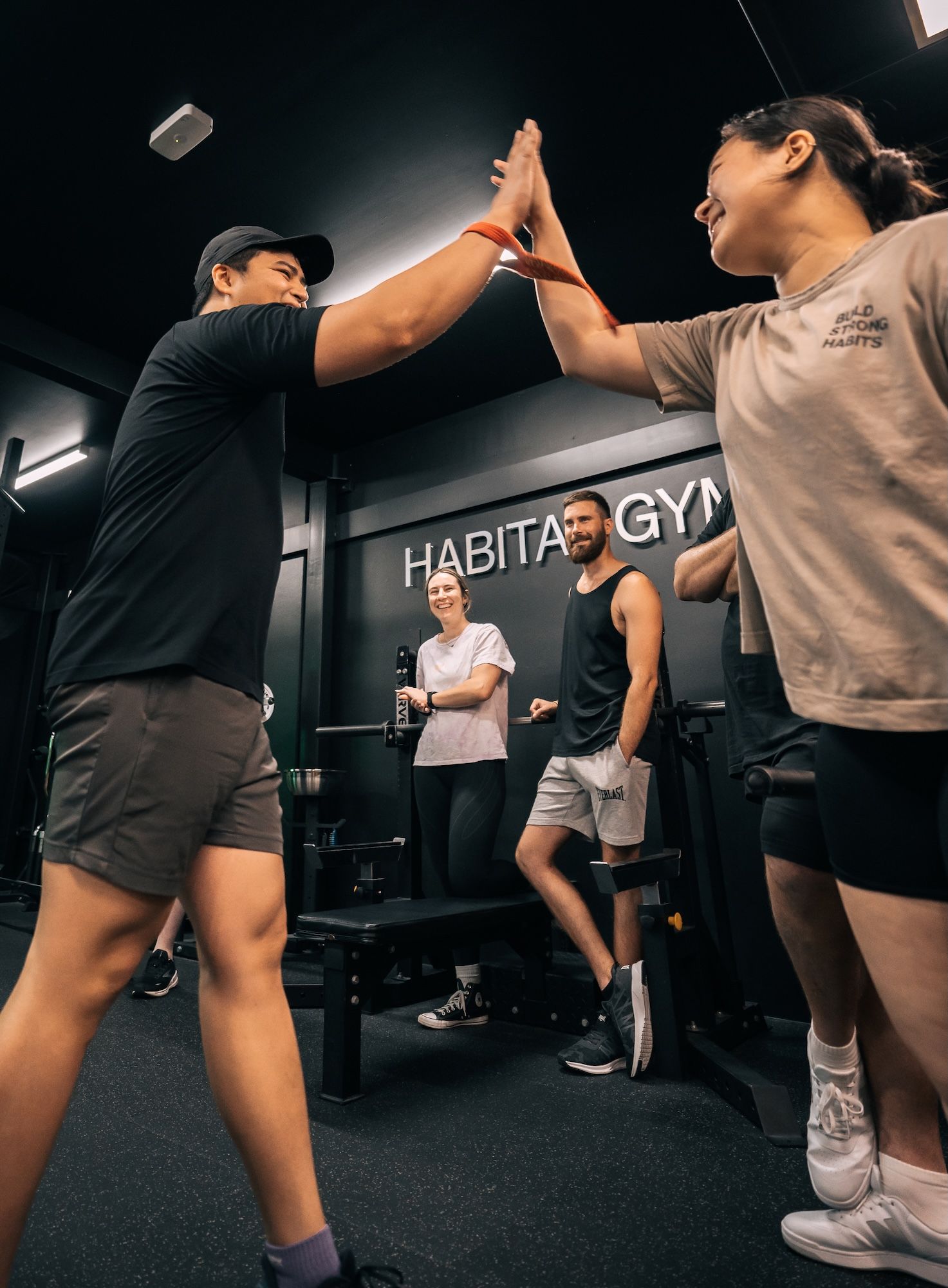 Habitat members hi-fiving each other at a community workshop hosted in Prestons gym