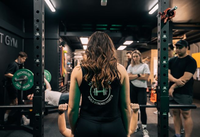 Habitat coach spotting a member whilst they are on the weight racks during semi-private session in Prestons gym