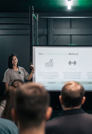 Coach Jeannie presenting the Build Strong Habits method during a workshop at Habitat Gym
